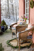 Korbstühle auf Veranda mit Blick in verschneiten Garten