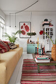 Vintage coffee table on a striped carpet, yellow sofa and wooden chest in the living room