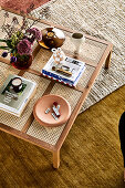 Rattan coffee table with flowers, books and bowl