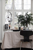 Black chair at festively decorated table with pale tablecloth