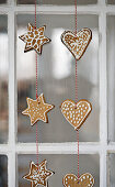 Gingerbread shapes threaded on string hung in window