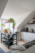 Kitchen island with rack in a white kitchen in the attic apartment