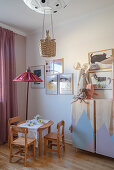 Children's table and chairs and standard lamp in corner of room