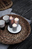 Lit candles and beakers on wicker tray