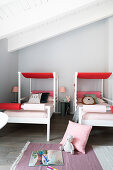 Partially covered beds in pink and red in the sibling room