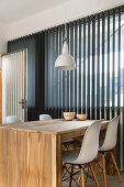 Wooden dining table and classic chairs next to window