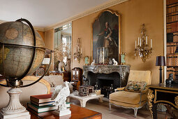 Large Georgian portrait above marble fireplace in drawing room with wall sconces and old globe