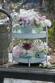 Metal etagere with pastel-colored bouquets of ranunculus and 'Petit Henry' 'Petit Jenny' carnation