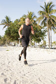 A grey-haired man jogging in black sports clothes