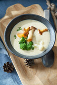 Cheese fondue soup with fried vegetables and chanterelles