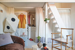 Walk-in closet behind curtain, white stairs to mezzanine