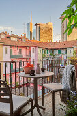 Bistro table with two chairs on the balcony, view of the neighboring building