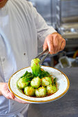 Chef serving pak choi with garlic and soy sauce