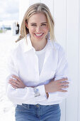 A long-haired blonde woman wearing a white shirt blouse