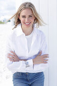 A long-haired blonde woman wearing a white shirt blouse