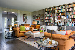Velvet sofas in Burnt orange with bookcase and lamps