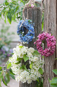 Wreaths of forget-me-nots, crab apple blossoms, and bird cherry hanging from posts