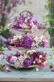 Spring table decoration on a cake stand with lilac blossoms, crabapple blossoms, and honesty flowers