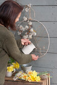 Woman creates hanging Easter decoration on the terrace