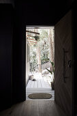 View from hallway with dark walls and wooden door to terrace