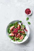 Wild herb salad with pomegranate seeds and figs