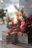 Candles in baking molds on a wooden star, Christmas tree ball, Christmas tree and rose hips