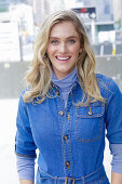 A young blonde woman wearing blue denim dungarees