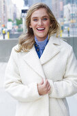 A young blonde woman wearing a white coat