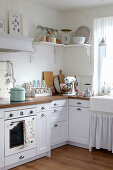 Kitchen with wooden worktop and pastel-coloured utensils