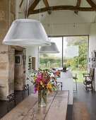 Half timbered ceiling over a refectory style table in an open kitchen living room