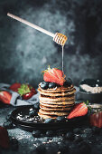 Healthy oat pancakes with berries and honey