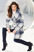 A brunette woman wearing plaid coat