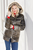 A blonde woman wearing a winter jacket with a fur hood