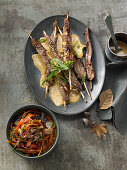 Lamb fillet skewers with saté sauce and vegetable salad