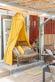 Rattan sofa with yellow canopy on the terrace