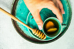 Spiced green tea served in the tea cup in woman hands