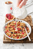 Granola with pomegranate and pouring milk