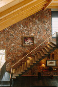 The staircase with the same pitch as the roof, with the stone wall as backdrop