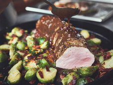 Roast wild boar with cranberry sauce and Brussels sprouts with pancetta
