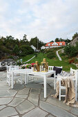 Seating area on terrace with view of house and garden