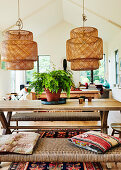 Dining area with wooden table and bench below pendant lights