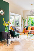 Small cast iron stove in front of dark green wall in eclectic living room