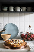 Apple cake and fresh apples on kitchen worktop