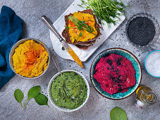 Beetroot hummus, hummus with spinach and black sesamy seeds and hummus with carrots