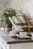 Coffee cups and cake stand on kitchen worktop