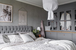Grey bedroom with double bed and hand-built wardrobe