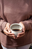 Woman holding mug of coffee in hands