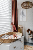 Baby basket on a chest of drawers in child's bedroom