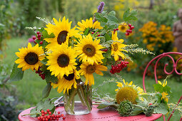 Strauß aus Sonnenblumen, Schneeballbeeren, Wermut und Duftnessel auf dem Tisch