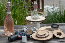 Make your own etagere from a bottle and wooden discs using a cordless drill and hole saw attachment